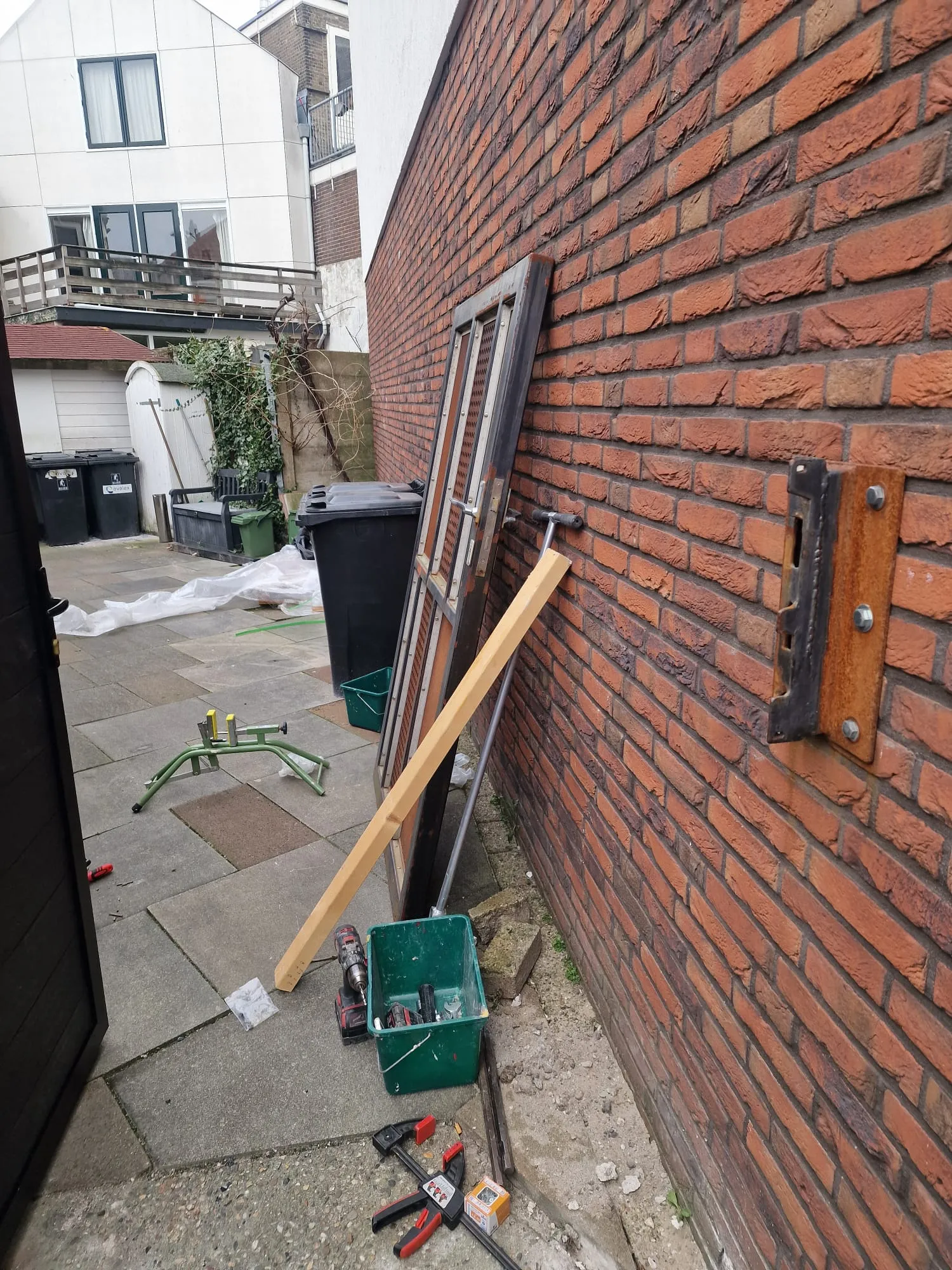 De oude poort is verwijderd; het metselwerk en de bevestigingspunten liggen klaar voor het nieuwe frame.