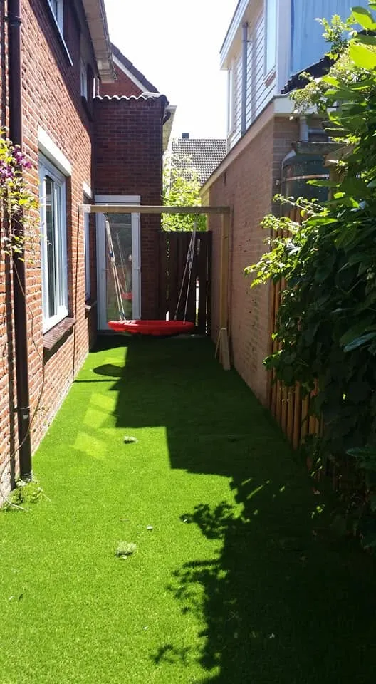 Tuin met kunstgras en speeltoestel