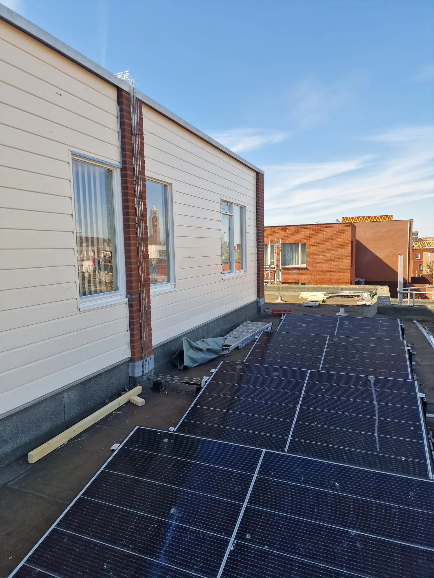 Vanaf het dak gezien sluit de nieuwe bekleding strak aan op de kozijnen en de metselwerkpenanten.