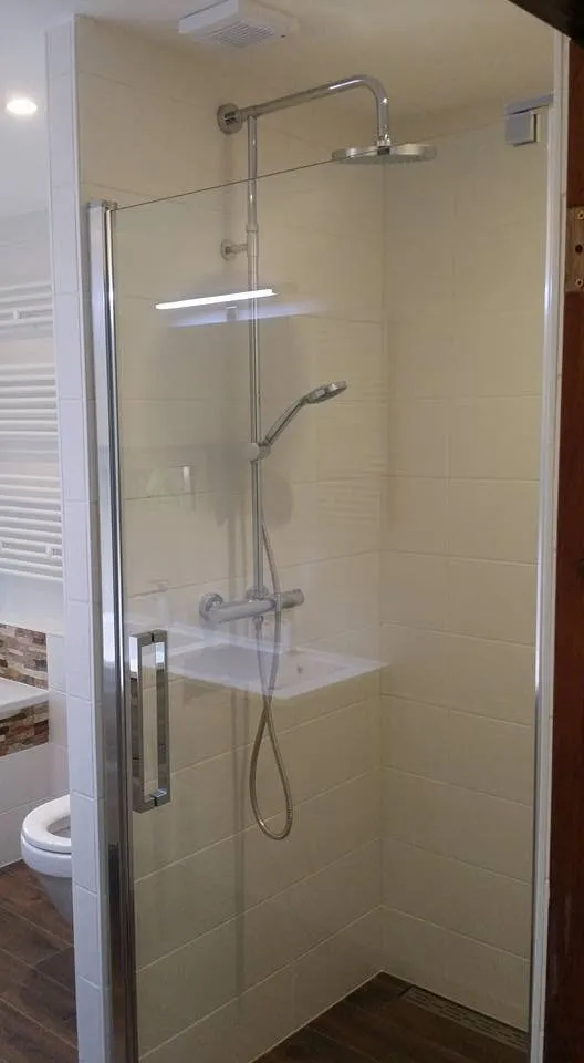 De inloopdouche met glazen wand, regendouche en handdouche, en een uitgespaarde nis met verlichting in de wand.