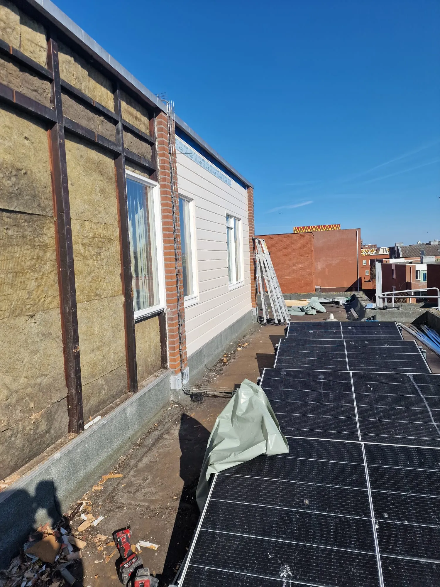 Halverwege het werk staat links het regelwerk met de isolatie nog open, terwijl rechts de nieuwe delen al zijn aangebracht.